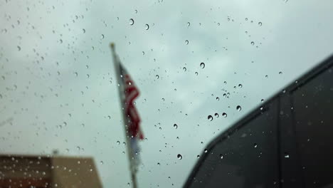 water on a window, american flag flowing in the background