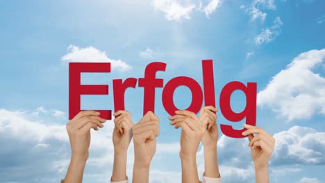 Woman-hand-holding-word-ERFOLG