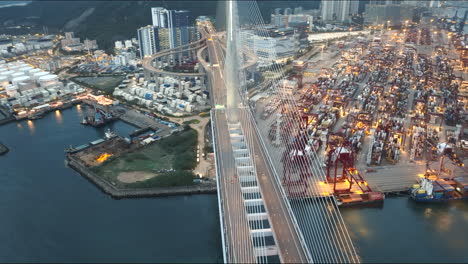 suspension bridge, hong kong, shipping container port in background, soft evening light, cinematic establishing wide angle aerial , anamorphic look