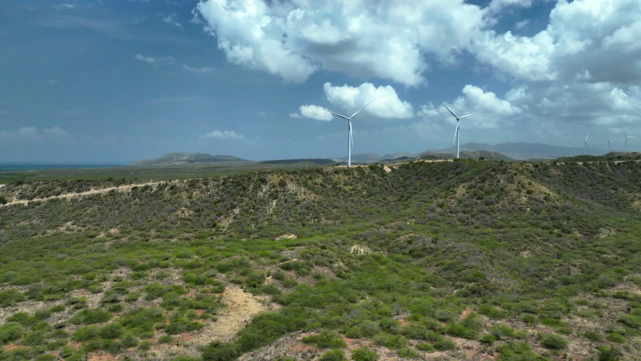 Turbine eoliche su un paesaggio collinare che si affaccia sull'oceano