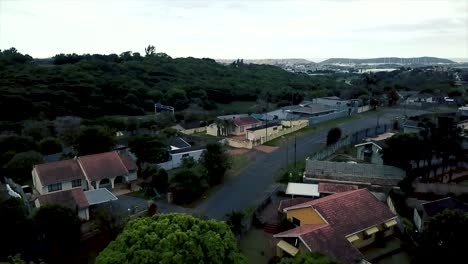 aerial footage of a drone flying over residential houses overlooking a busy highway with moving traffic in a suburb of yellow wood park durban