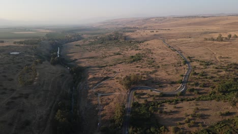 Geschwungene-Straße,-Die-Durch-Die-Landschaft-Neben-Dem-Fluss-Jordan,-Israel,-Führt,-Drohnenansicht