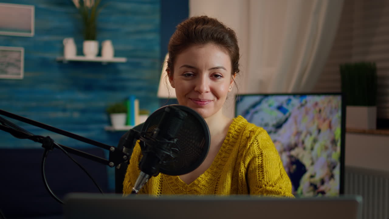 Woman blogger sitting in home studio looking at camera