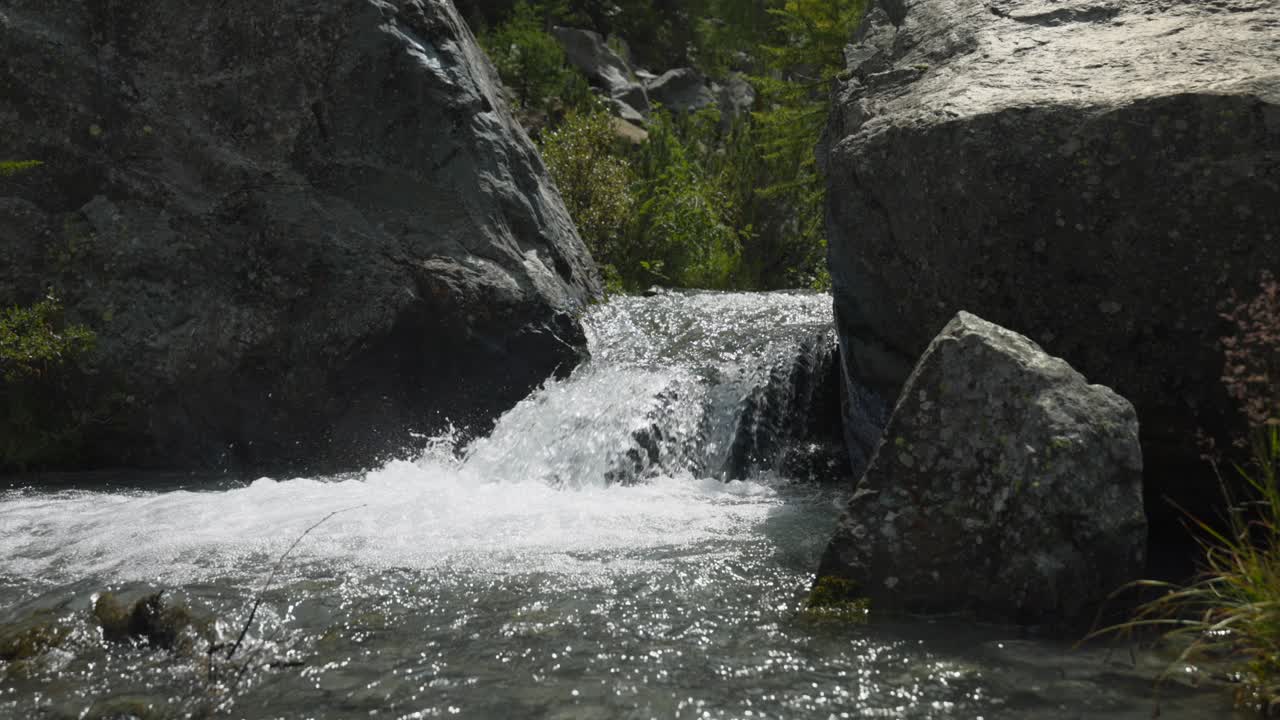 pequeña cascada entre las rocas en un día soleado en la temporada de verano