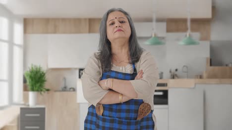 ama de casa india en edad de pie con las manos cruzadas