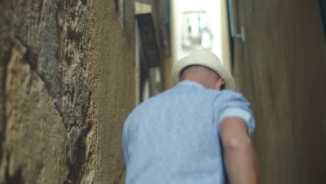 back view of happy male gay couple walking between houses