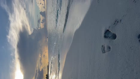 feet marked in the white sand on the seashore