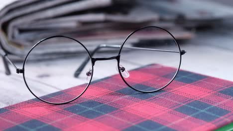 round glasses on a plaid notebook