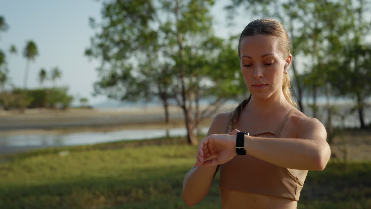 Young Woman Checking Smartwatch Before Outdoor Workout