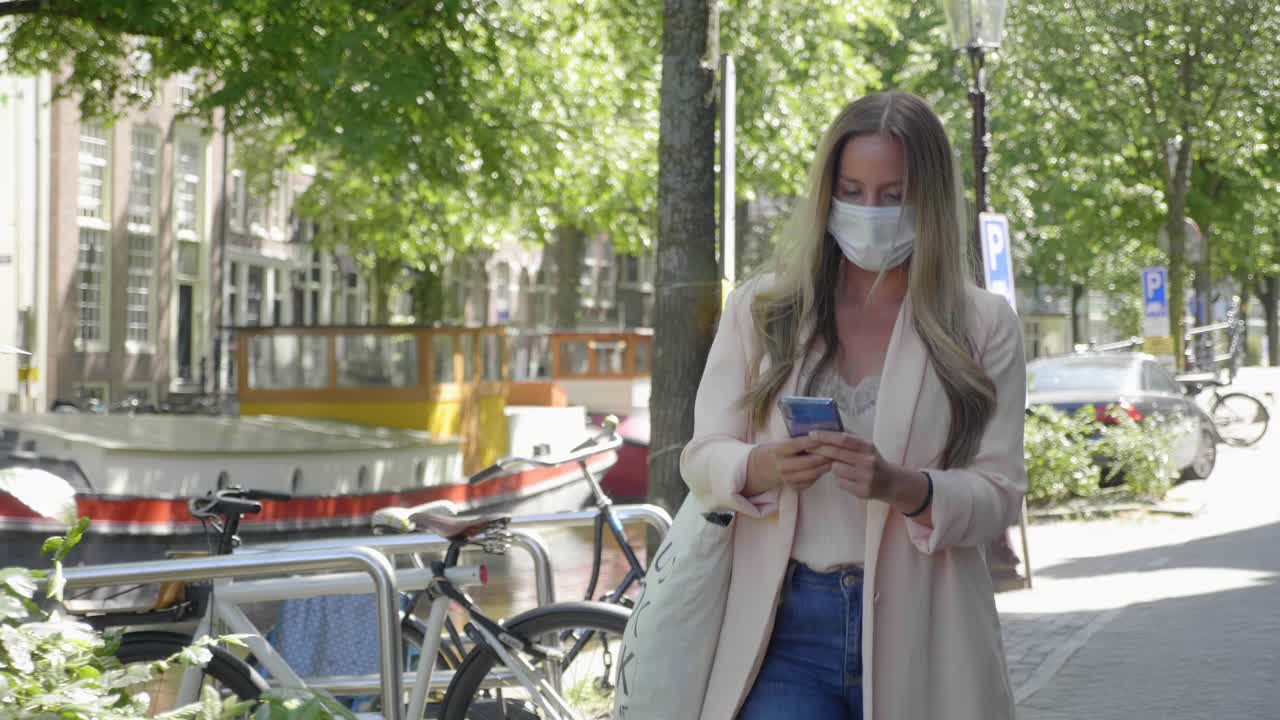 Beautiful Lady Wearing Medical Mask Walking Along The Road Near Amsterdam Canal In Netherlands Amidst Covid 19 Pandemic