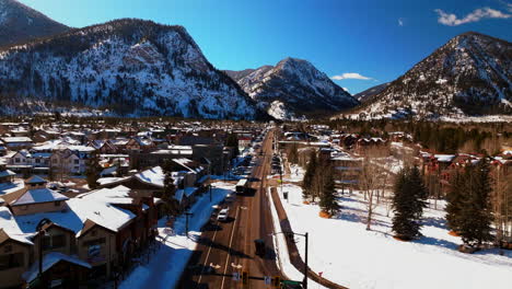 Winter-bluebird-sky-daytime-noon-snowy-downtown-Frisco-aerial-drone-car-traffic-main-street-Colorado-mountain-ski-town-Copper-MTN-Ikon-Pass-Breckenridge-Silverthorne-Dillon-Summit-County-forward-pan