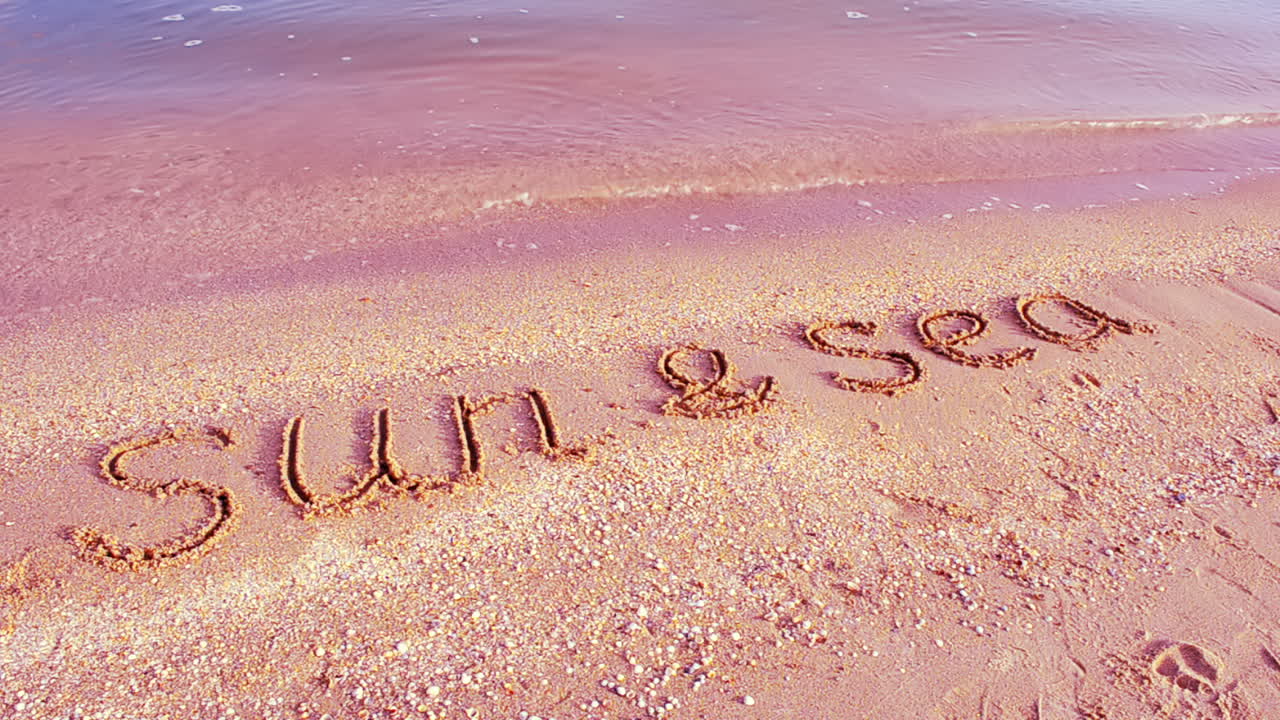 Giornata di sole, relax. Scritta "il sole" sulla sabbia, la spiaggia.