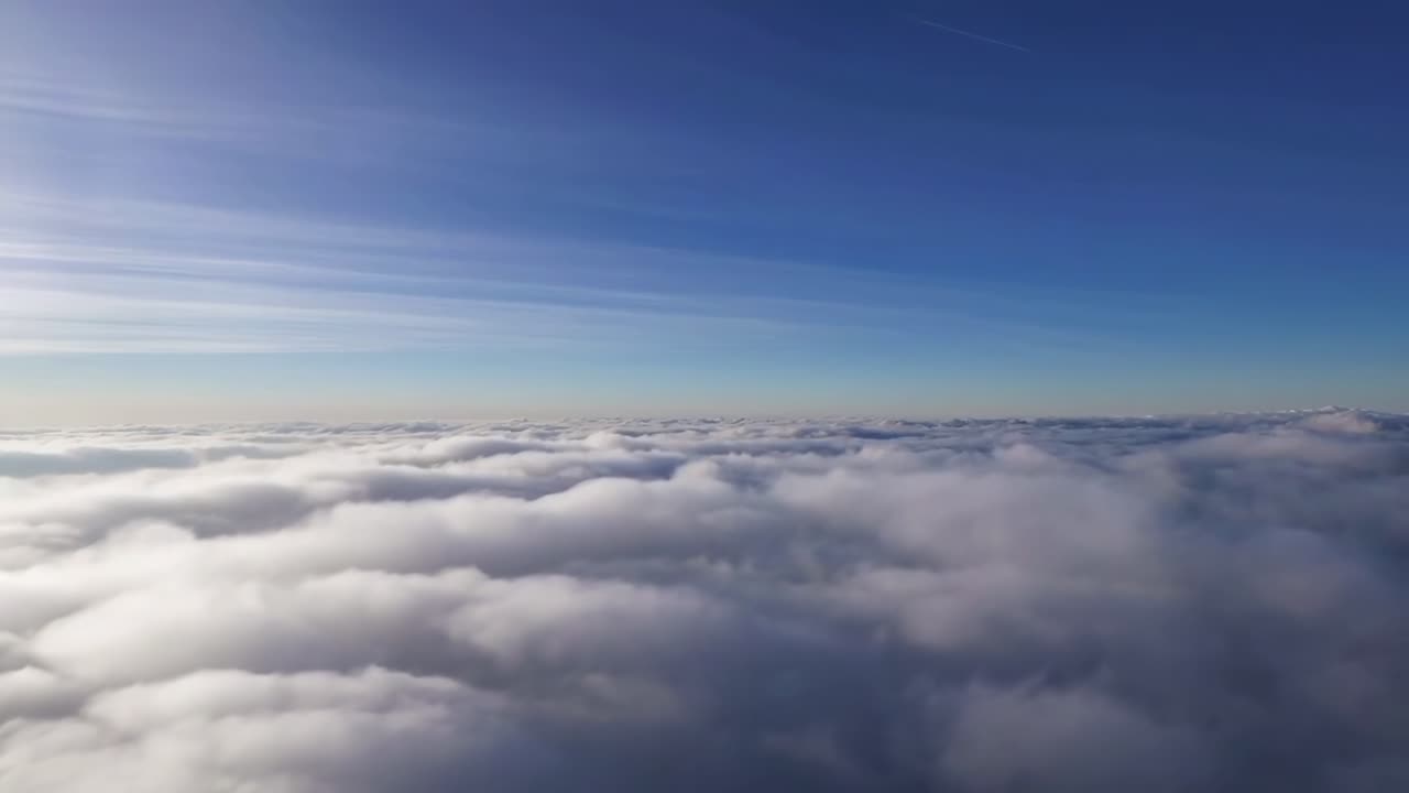 Aerial video view of fluffy clouds and blue sky, captured from a high angle perspective