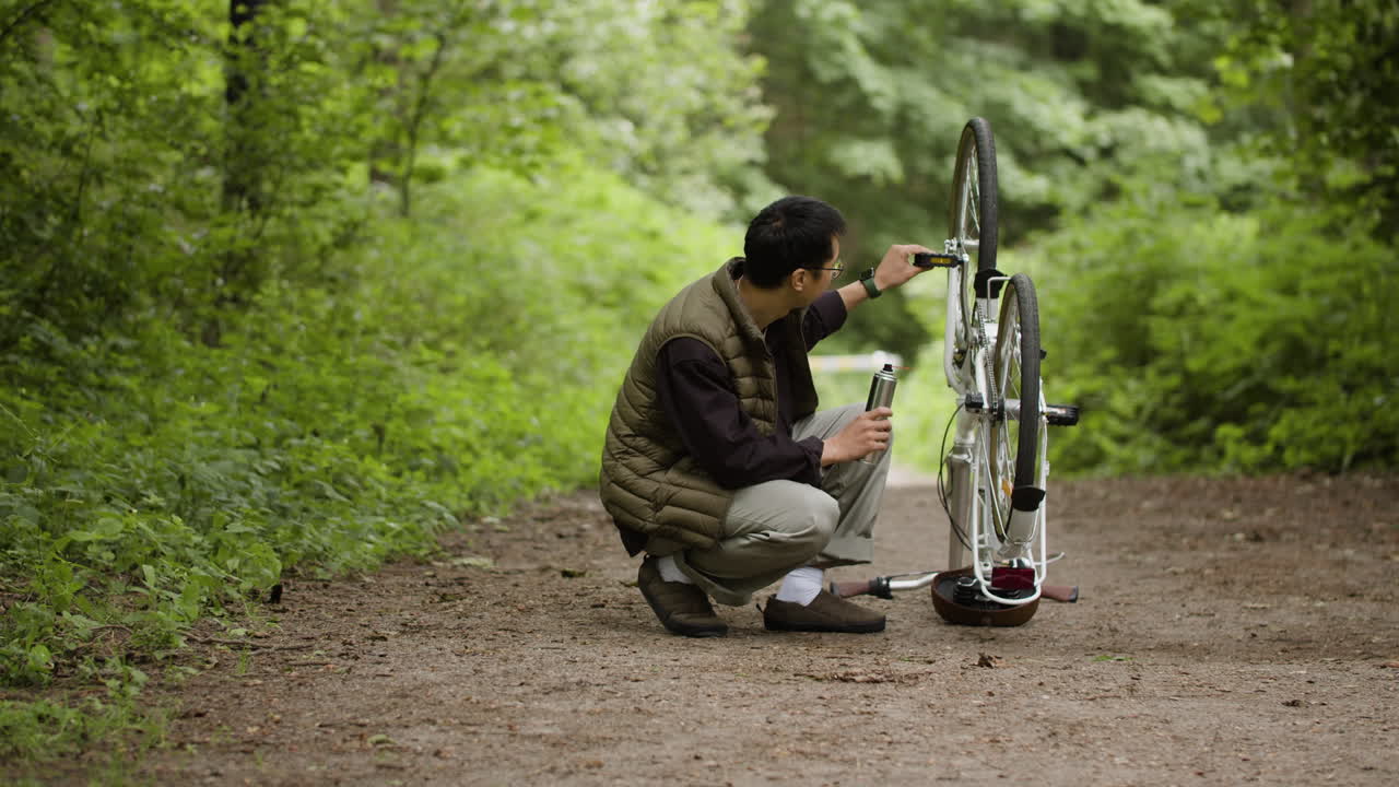 Man repairing a bicycle in the forest