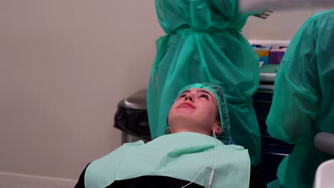 paciente femenina acostada en una silla escuchando música en una clínica dental