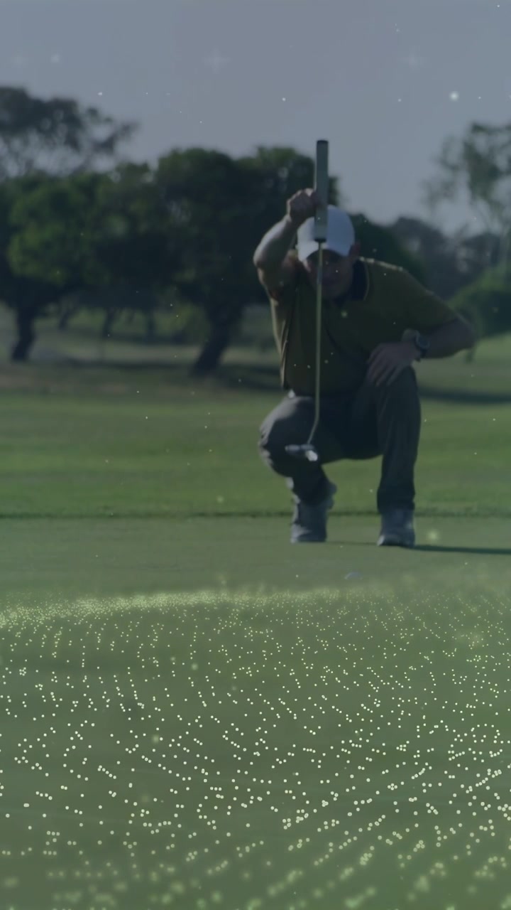 Video verticale: Telecamera che inquadra un golfista accovacciato sul green, con asta e punti per allineare il putt.