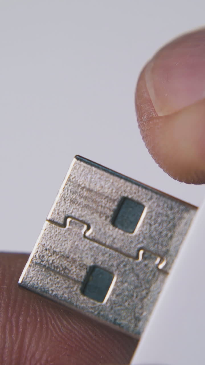 young person opens modern usb flash drive in white and orange case on light background extreme close view
