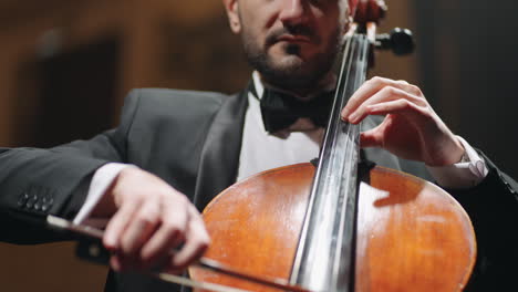 handsome man is playing cello on scene in concert hall violoncellist is playing classic music