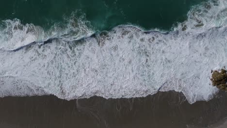 above view of foamy waves onto seacoast of playa valcovo in arteixo, a coruña, spain