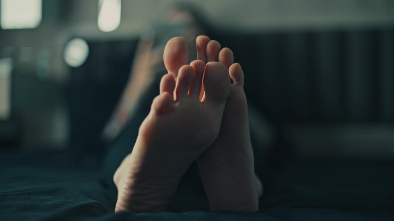 Person Relaxing on Bed with Feet Up