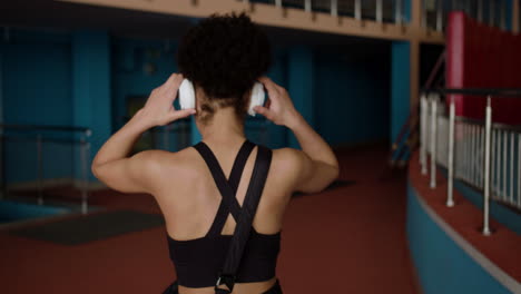 mujer afroamericana con auriculares en el gimnasio