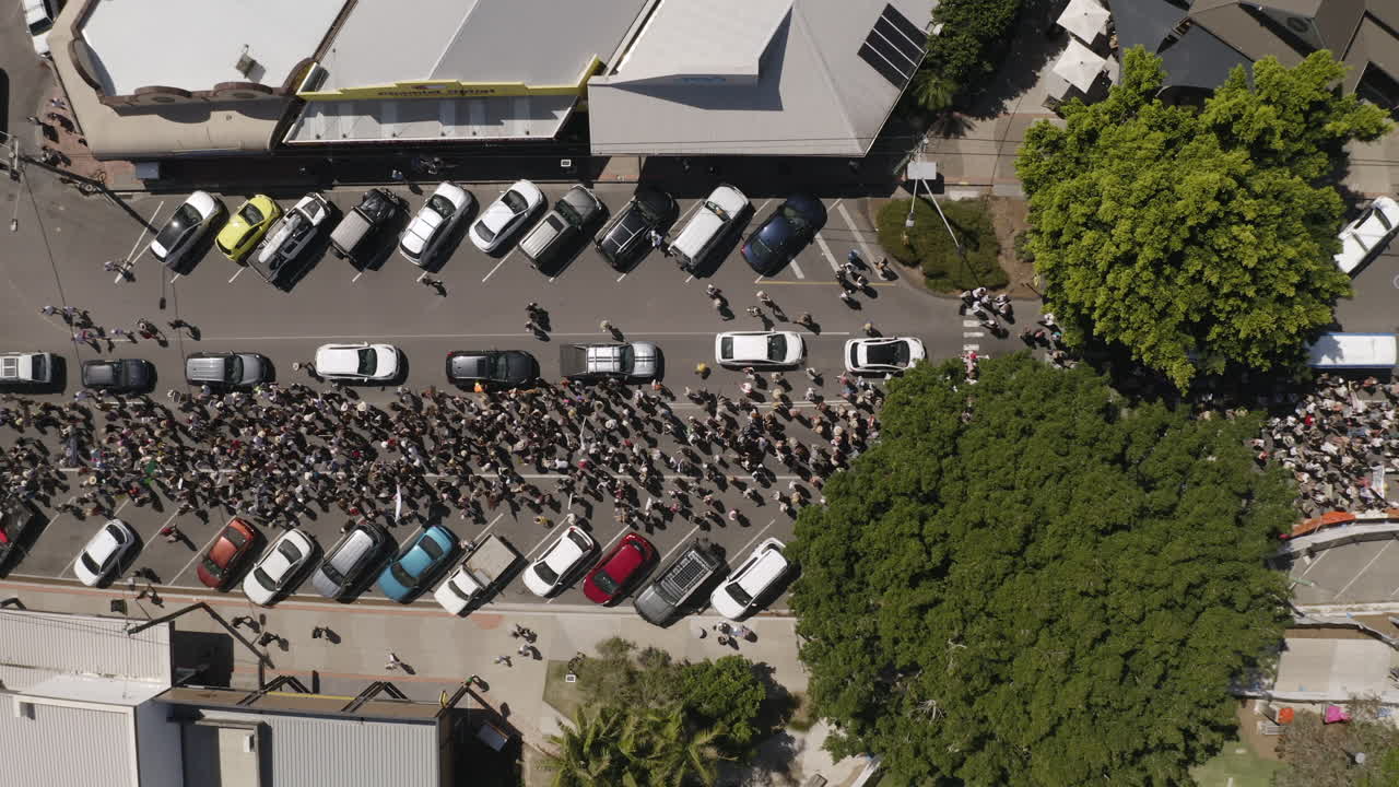vista superior de 4k toma de drones de mucha gente protestando en la carretera en byron bay, nueva gales del sur, australia