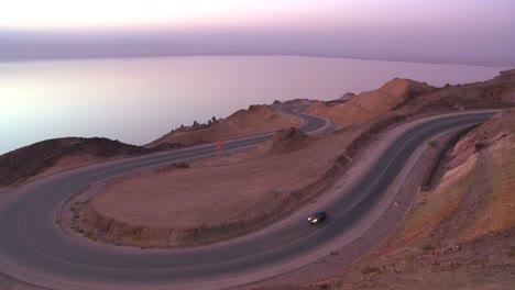 Un-Coche-Circula-Por-Una-Carretera-Sinuosa-Cerca-Del-Mar-Muerto-En-Jordania.