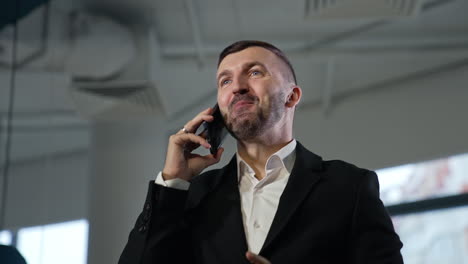 male entrepreneur speaking on the phone. happy expression on man's face during conversation. low angle view.