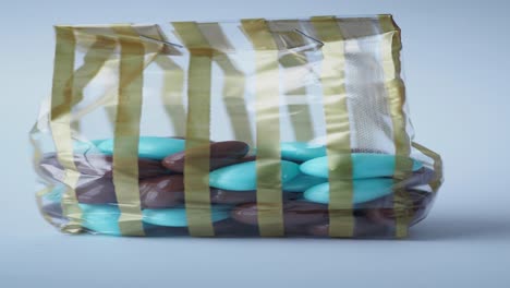 brown and blue almond chocolates in striped bag