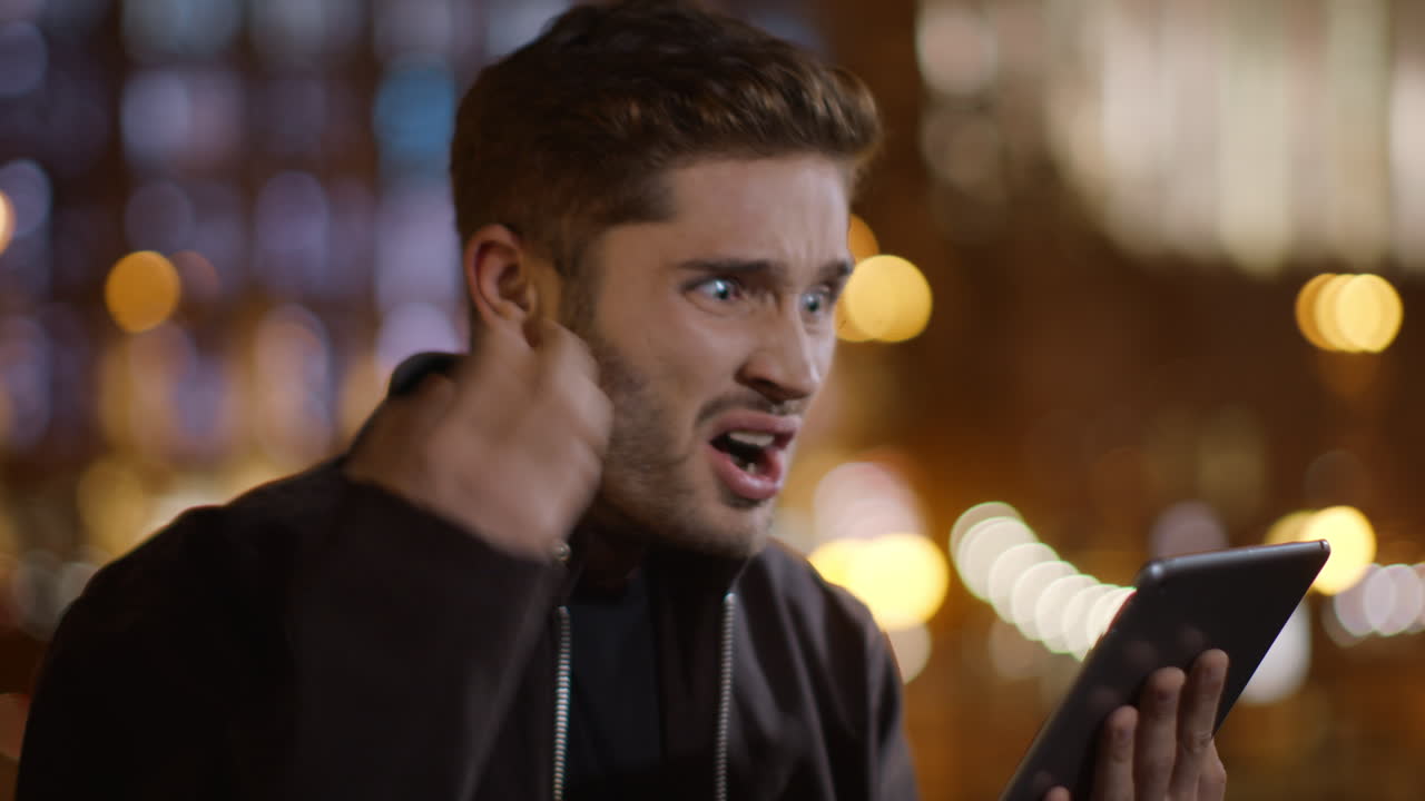 un hombre enojado maldiciendo con una tableta en las manos. un tipo grosero leyendo un mensaje en la tableta.