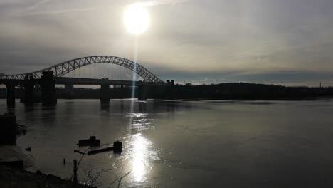 Sunrise-over-industrial-shipwreck-in-shimmering-river-Mersey-estuary-under-Silver-Jubilee-bridge