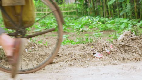 Blick-Auf-Die-Beine-Eines-Mannes,-Der-Auf-Ein-Fahrrad-Steigt,-Bevor-Er-In-Lang-Son-City,-Vietnam,-Abfährt,-Mit-Blick-Auf-Das-Landwirtschaftliche-Feld-Tagsüber