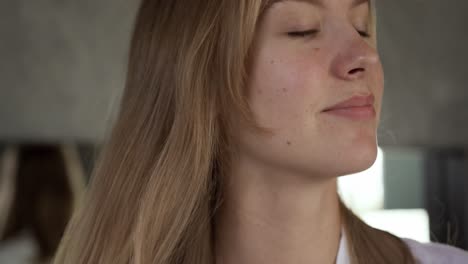 Close-up-view-of-caucasian-woman-brushing-hair-in-hotel