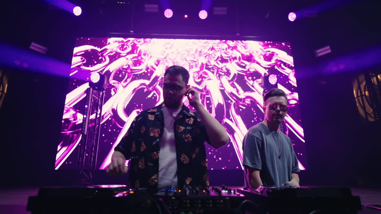 dos djs actuando en el escenario de un festival de música