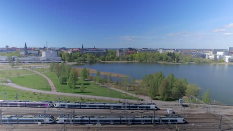 a slow moving aerial pull back shot of a beautiful boating marina adjacent to a series of train tracks