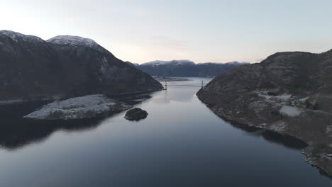 Lowering drone shot over the valley near Forsand Norway with the Bridge over Lysefjord in the background near sunset on a clear day LOG
