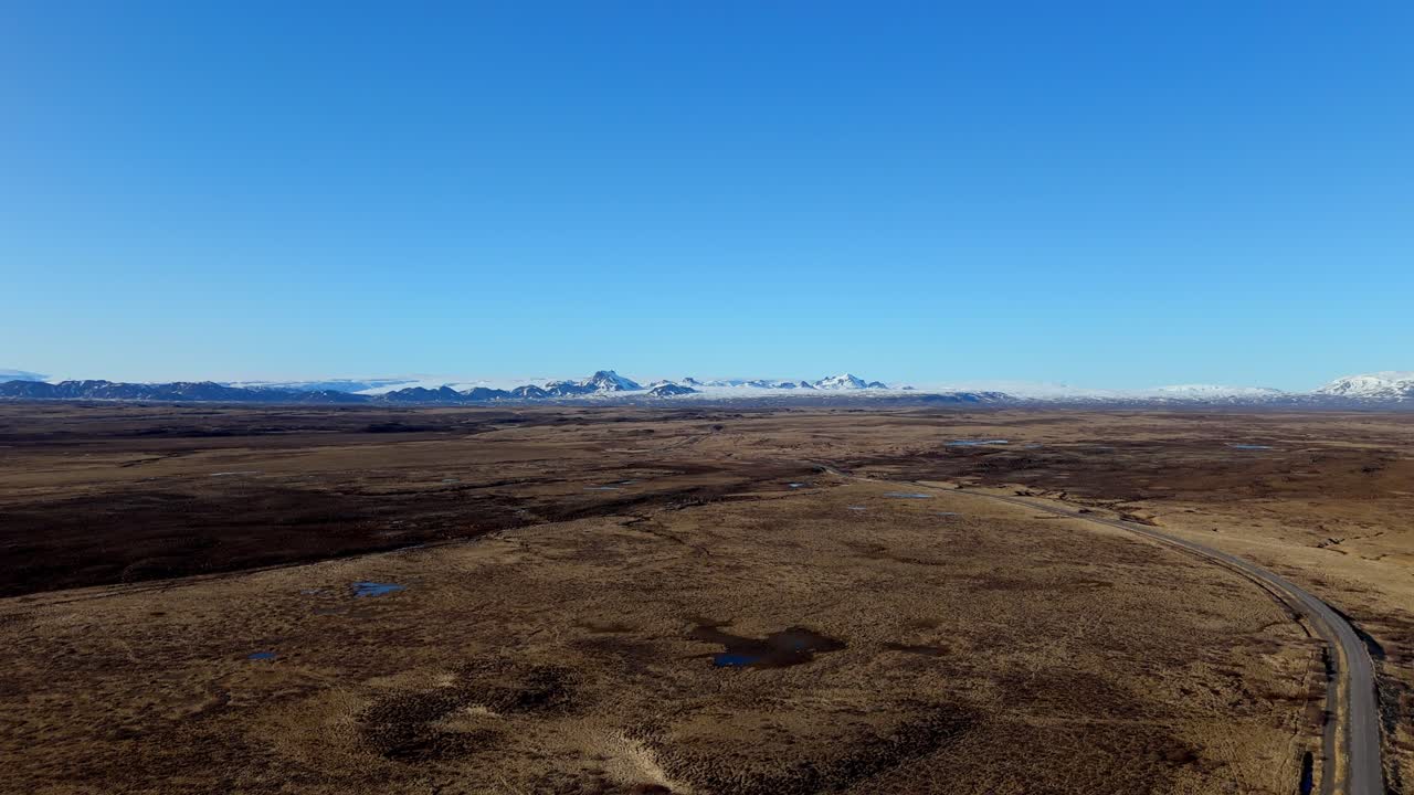 Aerial view of a distant glacier in Iceland. Vast icy expanse blends into rugged volcanic terrain under dramatic Arctic skies