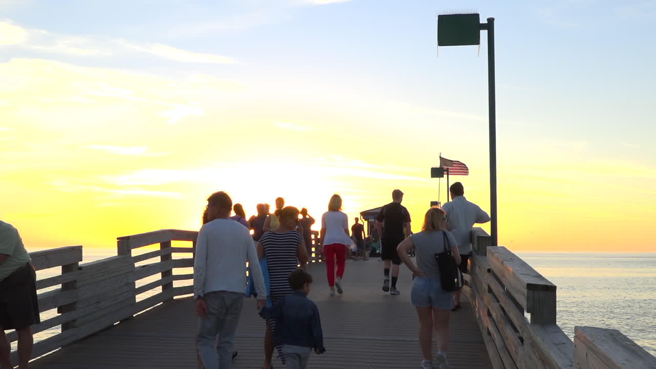 군중은 플로리다에서 일몰 부두에 걸어