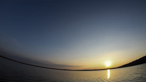 holy grail time lapse of the sunsetting and then the stars coming out next to lake with a fisheye lens