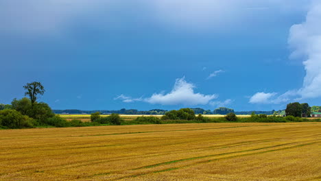 Flüchtige-Wolken-Am-Blauen-Himmel-Ziehen-über-Frisch-Geerntetes-Ackerland