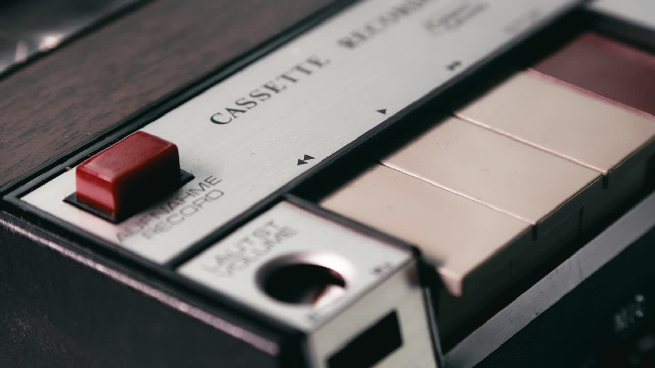 Finger operates retro compact cassette tape recorder CLOSE-UP