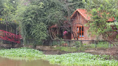 vista panorámica de una cabaña junto a un río con un puente