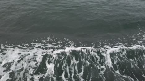 foamy waves splash on the side of a traveling ferry