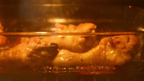 Frying-tasty-chicken-drumsticks-in-the-oven,-selective-focus