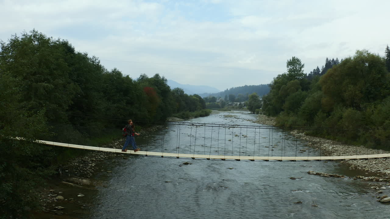 amantes cruzando el bosque río acampando actividad de senderismo montañas de fondo