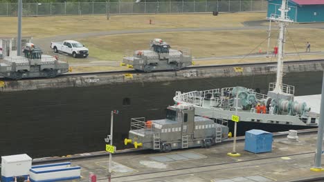 ship being towed through the panama canal by towing mules