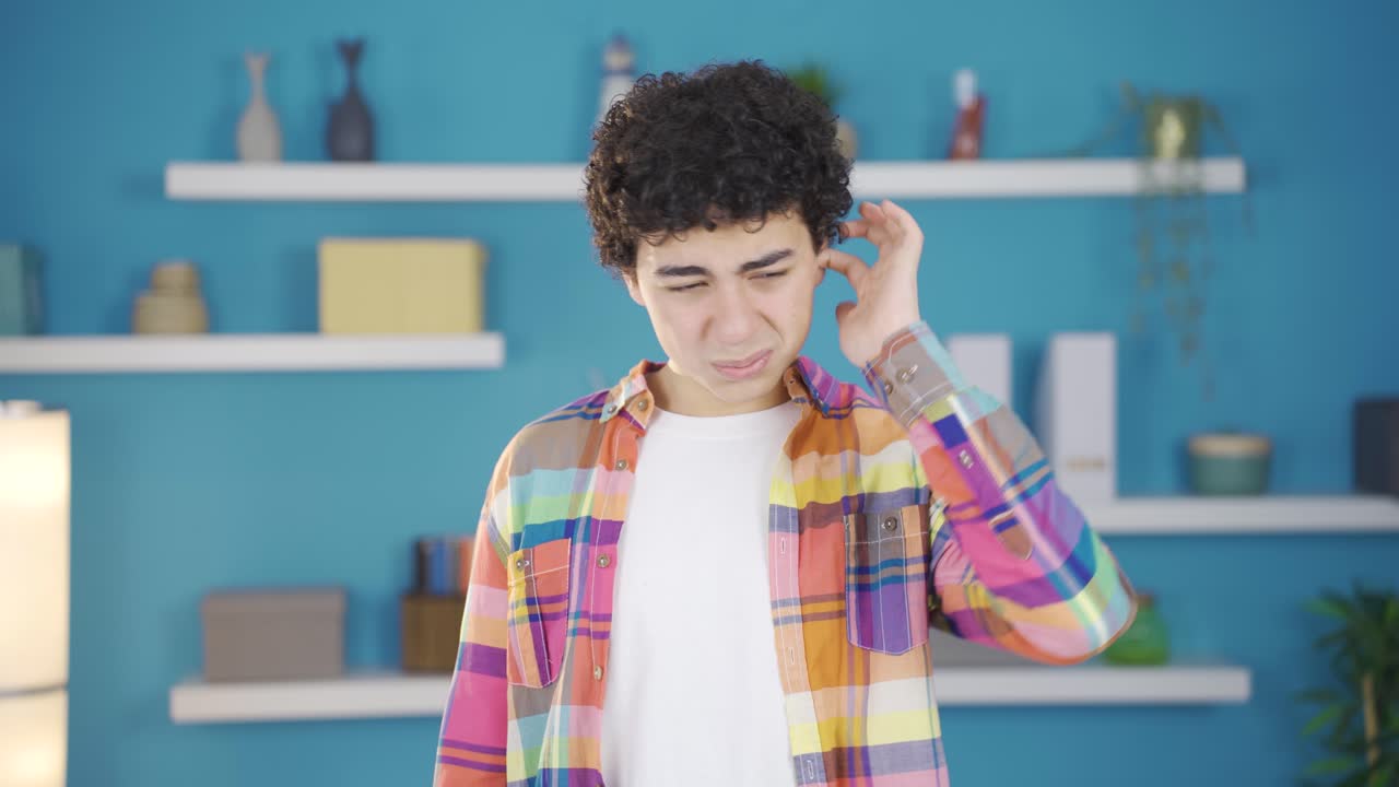 un chico enfermo y alérgico rascándose las orejas.