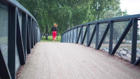 young girl running across a bridge in a park