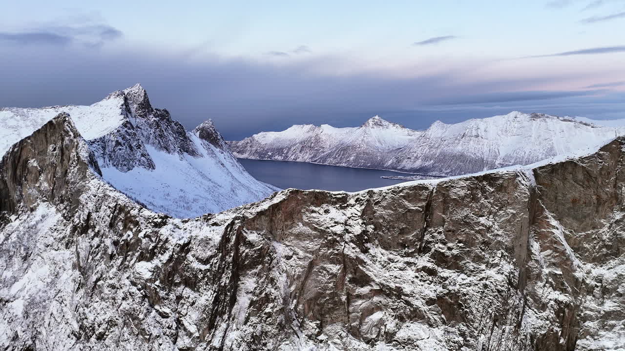 Cinematic aerial view of Hesten, one of the most photographed peaks on Senja Island, Norway, its horse-like shape towering over fjords and rugged Arctic landscapes in Troms og Finnmark County