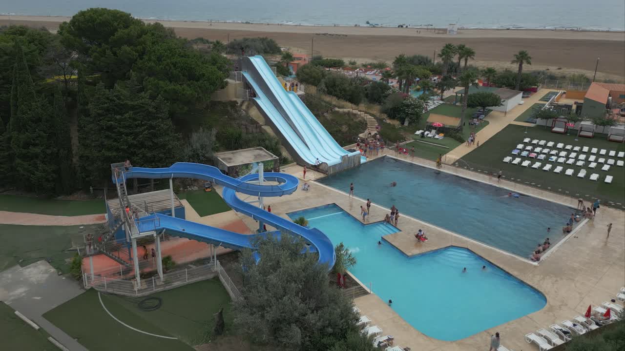 People enjoying summer day, acrobatics on water slide. Aerial circling